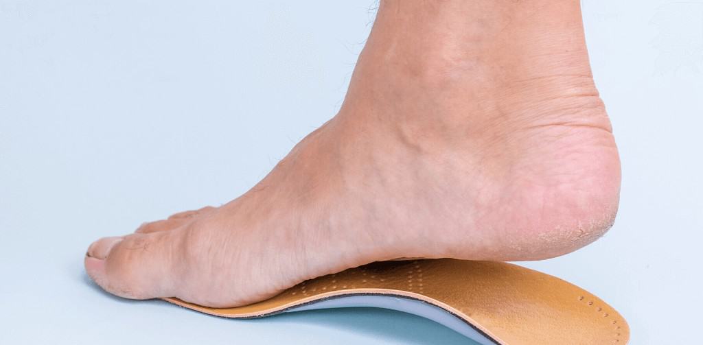 Man tries on orthotic with flat foot problem